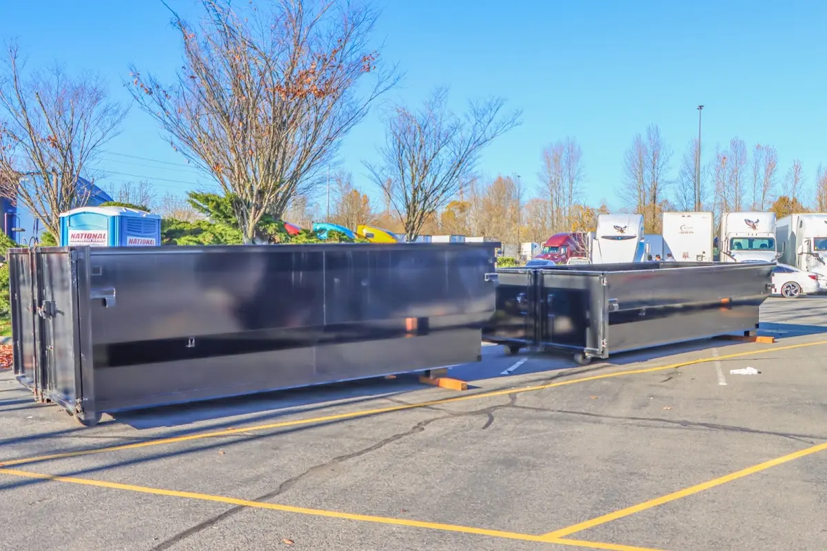 Professional dumpster rental service with roll-off container on residential driveway in Minot